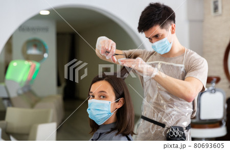 Woman client in mask during cuts hair at beauty salon Woman client in mask during cuts hair at beauty salon 80693605