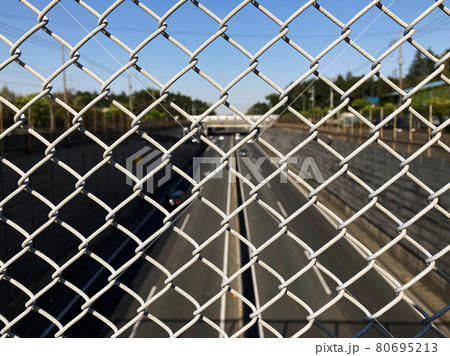 フェンス越しの真っ直ぐな道路　a straight road over the fence  80695213