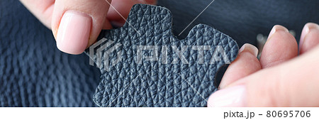 Female hands holding sample of genuine leather closeup Female hands holding sample of genuine leather closeup 80695706
