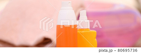 Lotion and sunscreen stand on sand on beach 80695736
