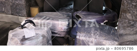 Packed suitcases in protective film on transport tape 80695786