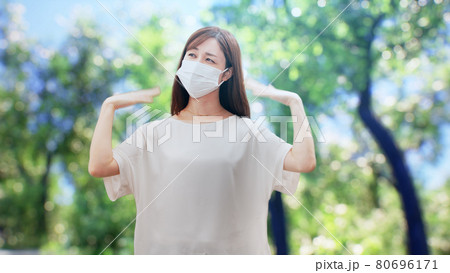 木々の前に立つ白い服を着た女性 80696171