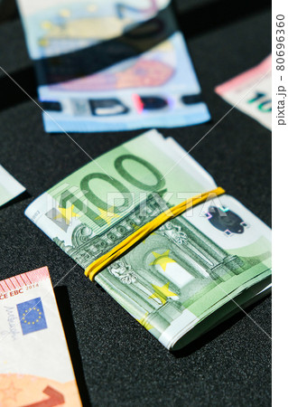 Close up of Euro money roll. Euro banknote set cash money - EU currency. Rolled with rubber euro notes. Banknotes stacked on each other in different positions Close up of Euro money roll. Euro banknote set cash money - EU currency. Rolled with rubber euro notes. Banknotes stacked on each other in different positions 80696360