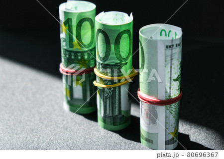 Close up of Euro money roll. Euro banknote set cash money - EU currency. Rolled with rubber euro notes. Banknotes stacked on each other in different positions Close up of Euro money roll. Euro banknote set cash money - EU currency. Rolled with rubber euro notes. Banknotes stacked on each other in different positions 80696367