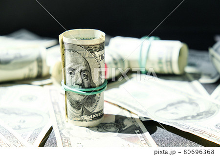 US dollars bundle close up isolated on dollar background. Paper denominations of dollars cash rolls with rubber bands. Business budget of wealth and prosperity finance. US dollars bundle close up isolated on dollar background. Paper denominations of dollars cash rolls with rubber bands. Business budget of wealth and prosperity finance. 80696368