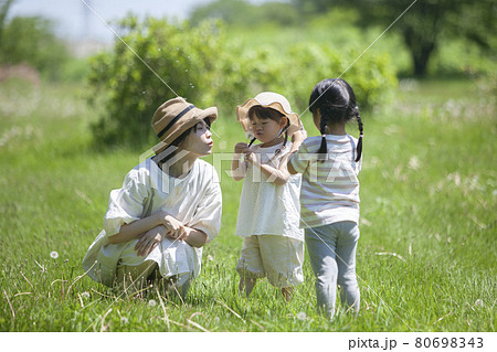 原っぱで遊ぶ保育士と子ども達 80698343