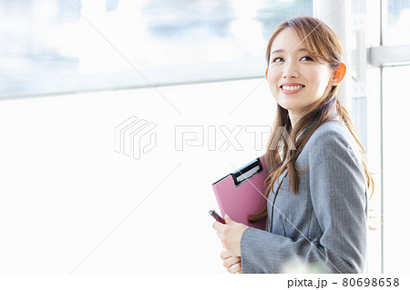 明るい窓際に立つ若いビジネスウーマン 80698658