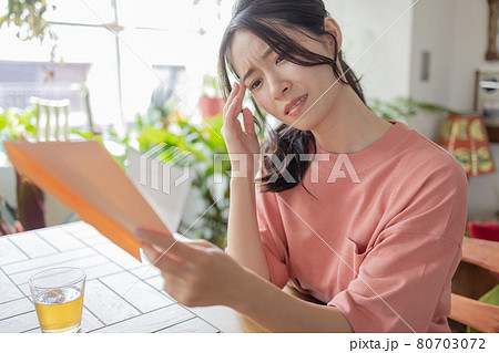 請求書を見て悩む若い女性 請求書を見て悩む若い女性 80703072