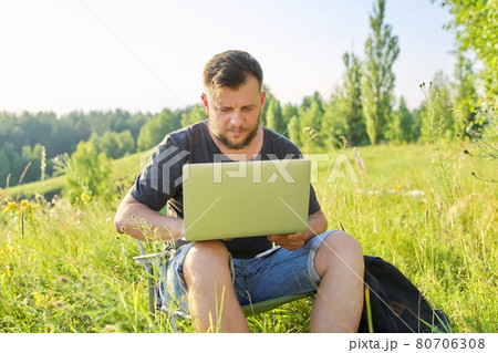 Middle-aged man with backpacks with laptop in nature 80706308