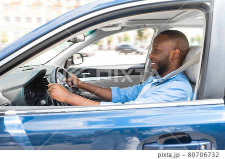 Smiling black man driving new car in city Smiling black man driving new car in city 80706732