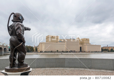 A bronze figure of a diver stands on a pedestal on the waterfront. A bronze figure of a diver stands on a pedestal on the waterfront. 80710082