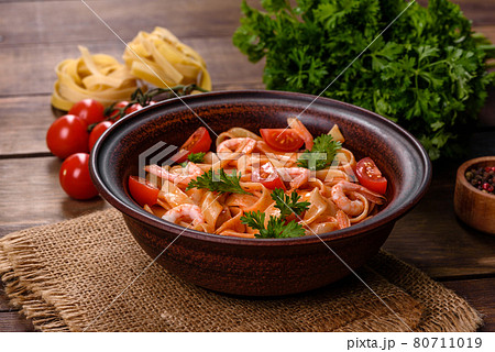 Fettuccine pasta with shrimp, cherry tomatoes, sauce, spices and herbs Fettuccine pasta with shrimp, cherry tomatoes, sauce, spices and herbs 80711019