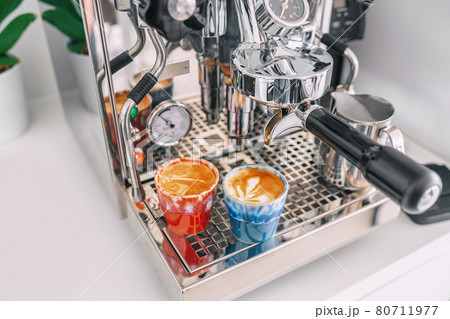 Two macchiato shots in espresso cups on coffee machine at home - white apartment kitchen, modern interior lifestyle 80711977