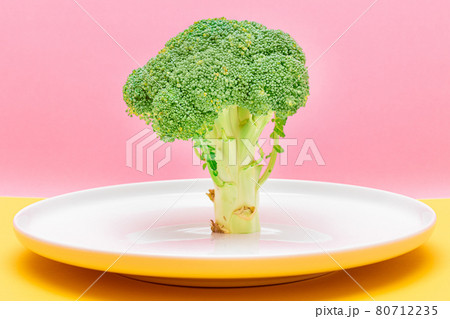 Fresh and Raw Broccoli on White Dish. Uncooked Green Cabbage Fresh and Raw Broccoli on White Dish. Uncooked Green Cabbage 80712235