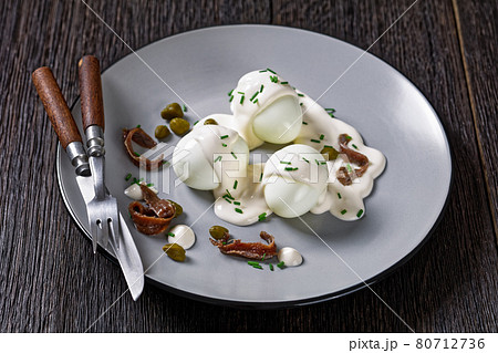 boiled eggs with mayo, anchovy fillets and capers 80712736