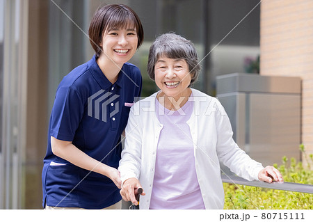 介護イメージ　杖をついて歩くシニア女性と介護士　撮影協力：中央工学校附属日本語学校 80715111