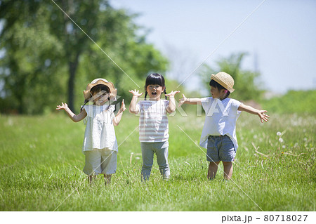 芝生の公園で遊ぶ3人の女の子 80718027