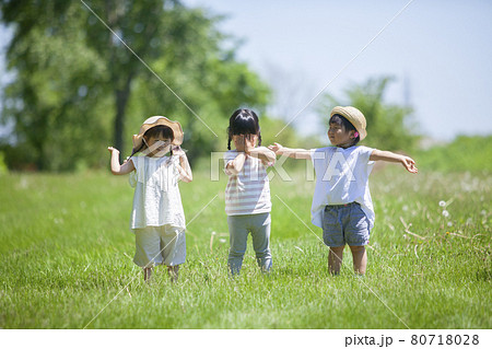 芝生の公園で遊ぶ3人の女の子 80718028