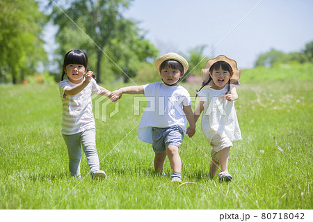 芝生の公園で遊ぶ3人の女の子 芝生の公園で遊ぶ3人の女の子 80718042
