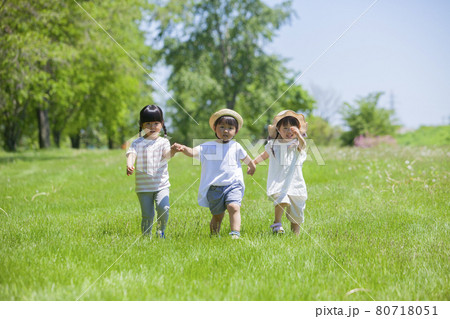 芝生の公園で遊ぶ3人の女の子 芝生の公園で遊ぶ3人の女の子 80718051