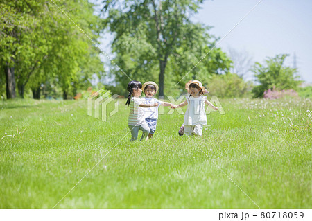 芝生の公園で遊ぶ3人の女の子 80718059