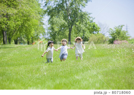 芝生の公園で遊ぶ3人の女の子 80718060