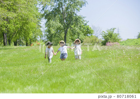 芝生の公園で遊ぶ3人の女の子 芝生の公園で遊ぶ3人の女の子 80718061