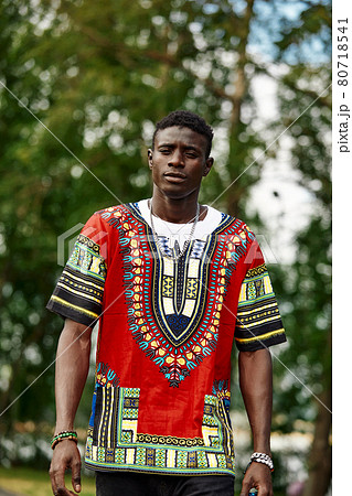 A black man walks in the park, an attractive black man, smiling, walks through the city park, rest, relaxation, unity with nature. A black man walks in the park, an attractive black man, smiling, walks through the city park, rest, relaxation, unity with nature. 80718541