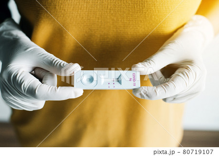 Patient woman showing result a covid-19 self test rapid antigen testing kit at home Patient woman showing result a covid-19 self test rapid antigen testing kit at home 80719107