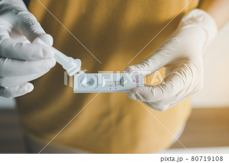 Patient woman showing result a covid-19 self test rapid antigen testing kit at home 80719108