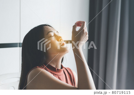 Patient asian woman doing a nasal swab self test rapid antigen testing kit for checking a covid-19 at home 80719115