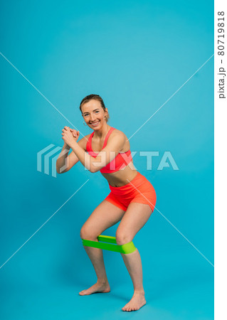 Self determined bodybuilder does exercises with rubber band, works on hands and legs. Sport concept. Self determined bodybuilder does exercises with rubber band, works on hands and legs. Sport concept. 80719818