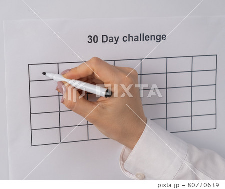 Cropped view of woman writing check marks in boxes of 30 days challenge Cropped view of woman writing check marks in boxes of 30 days challenge 80720639