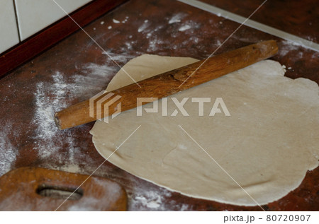 Dough, cutting board and rolling pin on the kitchen table. Dough, cutting board and rolling pin on the kitchen table. 80720907