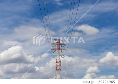 青空と雲の中に立つ赤と白に塗装された高圧送電塔の写真素材 [80721985 ...