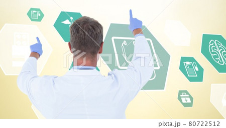 Composition of male doctor over digital icons on yellow background 80722512