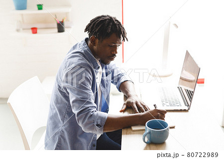 African american male painter at work using laptop and taking notes in art studio African american male painter at work using laptop and taking notes in art studio 80722989