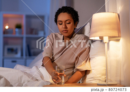 african american woman drinking water at night african american woman drinking water at night 80724073