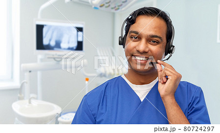 smiling indian doctor or male nurse with headset smiling indian doctor or male nurse with headset 80724297