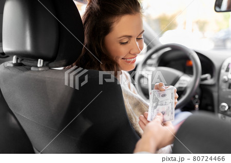 female car driver taking money from passenger 80724466