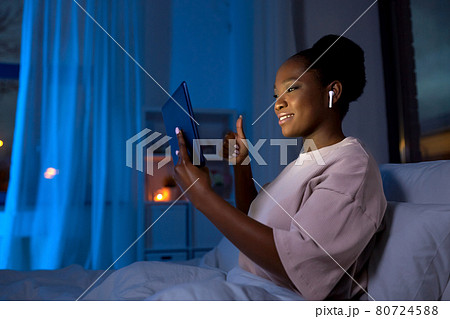woman with tablet pc having video call at night woman with tablet pc having video call at night 80724588