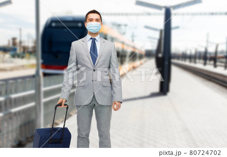 businessman in mask with travel bag over train businessman in mask with travel bag over train 80724702