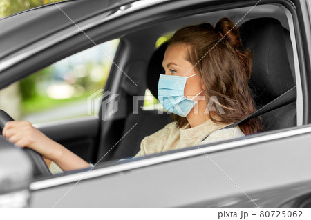 woman or female driver in mask driving car in city woman or female driver in mask driving car in city 80725062