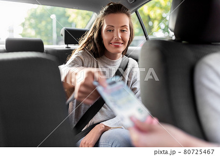 female passenger giving money to taxi car driver 80725467