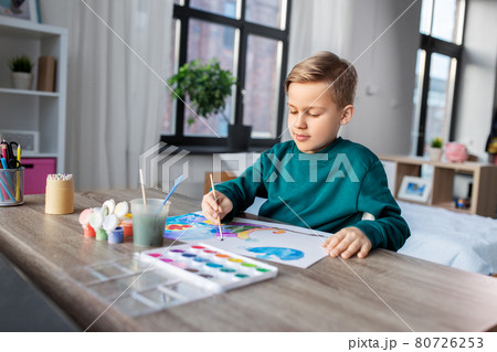 boy with colors and brush drawing picture at home boy with colors and brush drawing picture at home 80726253