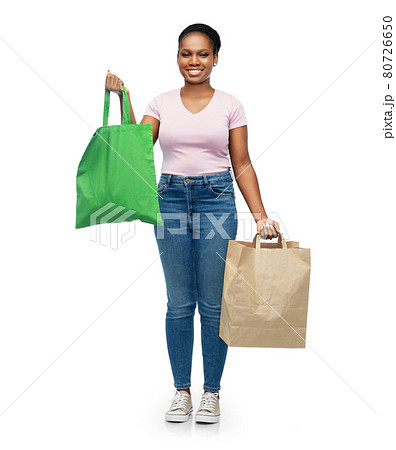 woman comparing reusable and paper bags woman comparing reusable and paper bags 80726650