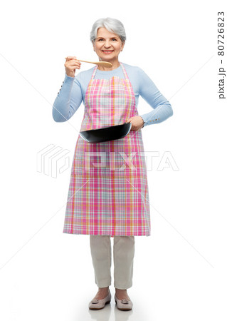 smiling senior woman in apron with frying pan smiling senior woman in apron with frying pan 80726823
