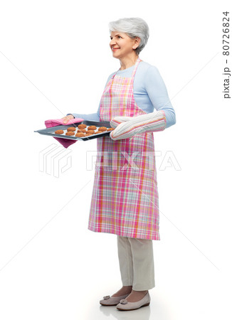 senior woman in apron with cookies on baking pan 80726824