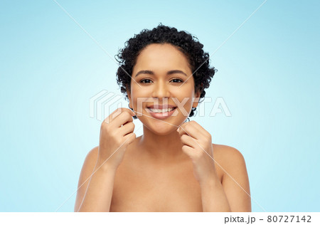 african woman cleaning teeth with dental floss african woman cleaning teeth with dental floss 80727142