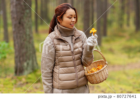 young woman picking mushrooms in autumn forest young woman picking mushrooms in autumn forest 80727641